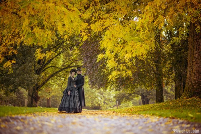 Couple en tenue victorienne dans un parc d'automne