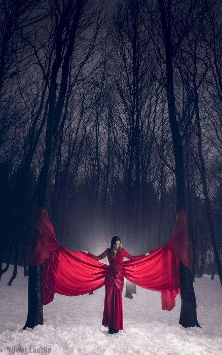 Silhouette en rouge dans une forêt enneigée